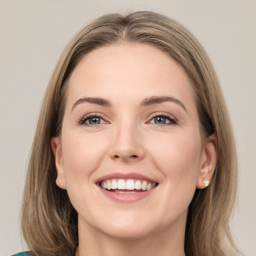 Joyful white young-adult female with long  brown hair and green eyes