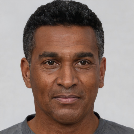 Joyful black adult male with short  black hair and brown eyes