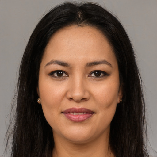 Joyful latino young-adult female with long  brown hair and brown eyes