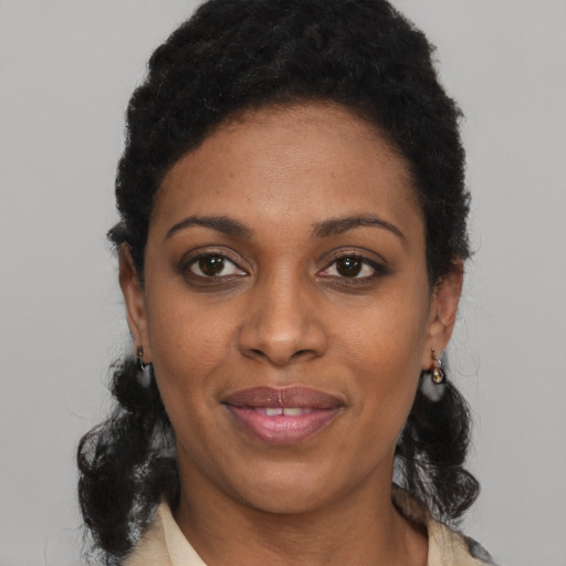 Joyful black young-adult female with short  black hair and brown eyes