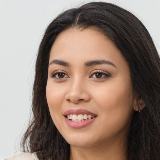 Joyful latino young-adult female with long  brown hair and brown eyes