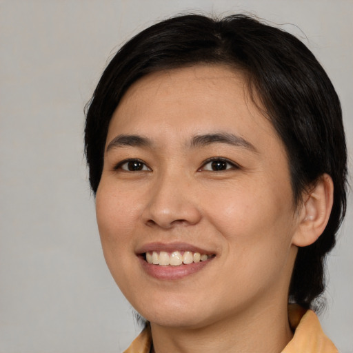 Joyful asian young-adult female with medium  brown hair and brown eyes