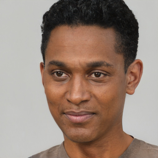 Joyful black young-adult male with short  black hair and brown eyes