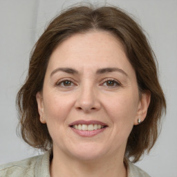 Joyful white adult female with medium  brown hair and grey eyes