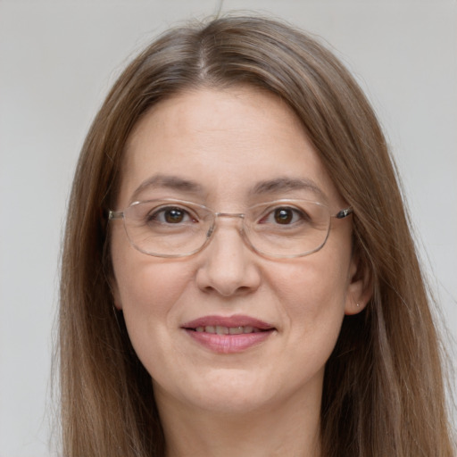 Joyful white adult female with long  brown hair and grey eyes