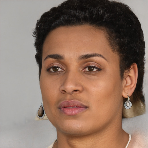 Joyful black young-adult female with short  black hair and brown eyes