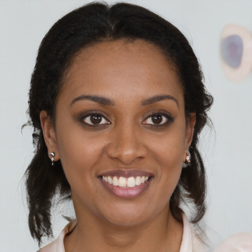 Joyful black young-adult female with medium  brown hair and brown eyes