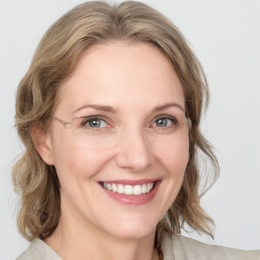 Joyful white young-adult female with medium  brown hair and blue eyes