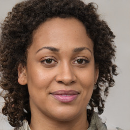 Joyful black adult female with medium  brown hair and brown eyes