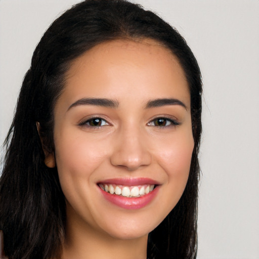 Joyful latino young-adult female with long  brown hair and brown eyes