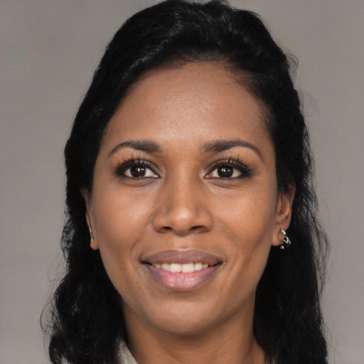 Joyful black young-adult female with long  black hair and brown eyes