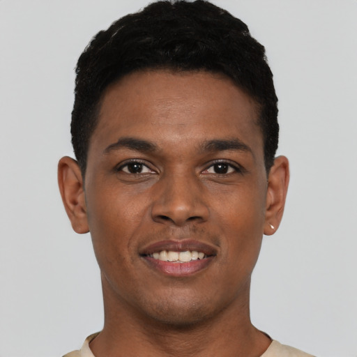 Joyful black young-adult male with short  black hair and brown eyes