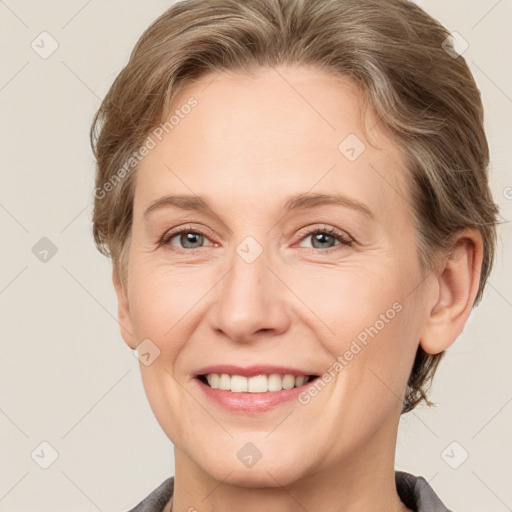 Joyful white adult female with short  brown hair and grey eyes