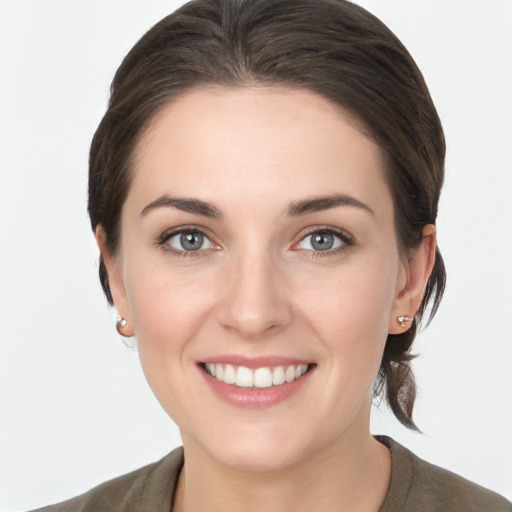 Joyful white young-adult female with medium  brown hair and grey eyes