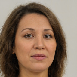 Joyful white adult female with long  brown hair and brown eyes