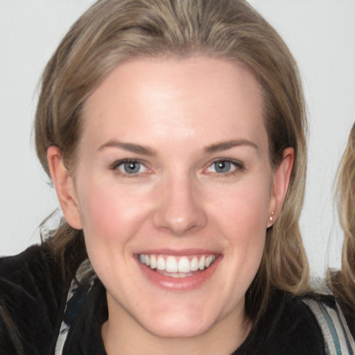 Joyful white young-adult female with medium  brown hair and blue eyes