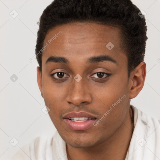 Joyful black young-adult male with short  brown hair and brown eyes