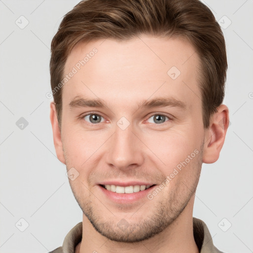 Joyful white young-adult male with short  brown hair and grey eyes