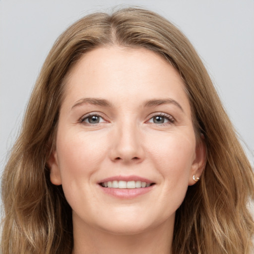 Joyful white young-adult female with long  brown hair and grey eyes