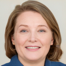 Joyful white adult female with medium  brown hair and blue eyes