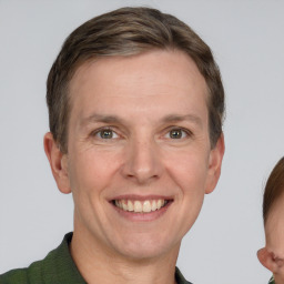 Joyful white adult male with short  brown hair and grey eyes