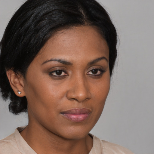 Joyful black young-adult female with medium  brown hair and brown eyes