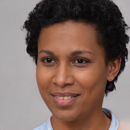 Joyful black adult female with short  brown hair and brown eyes