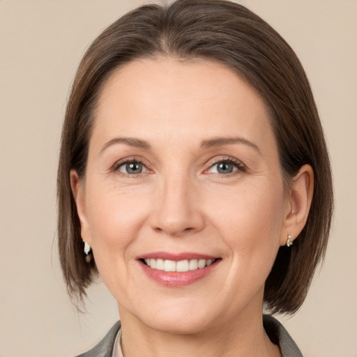 Joyful white adult female with medium  brown hair and grey eyes