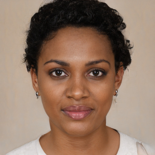 Joyful black young-adult female with short  black hair and brown eyes