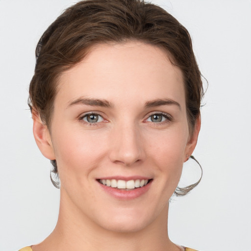 Joyful white young-adult female with short  brown hair and grey eyes