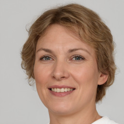 Joyful white adult female with medium  brown hair and green eyes