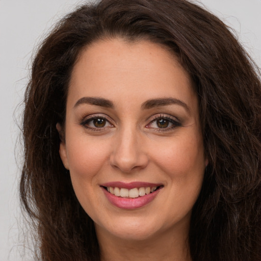 Joyful white young-adult female with long  brown hair and brown eyes