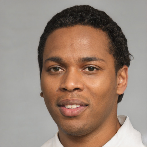 Joyful black young-adult male with short  black hair and brown eyes