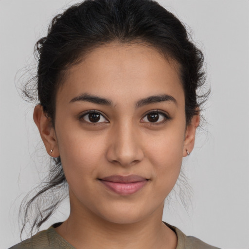 Joyful latino young-adult female with medium  brown hair and brown eyes