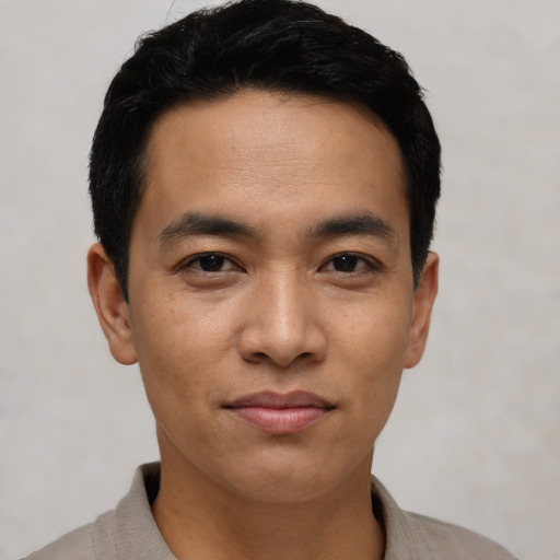 Joyful asian young-adult male with short  black hair and brown eyes
