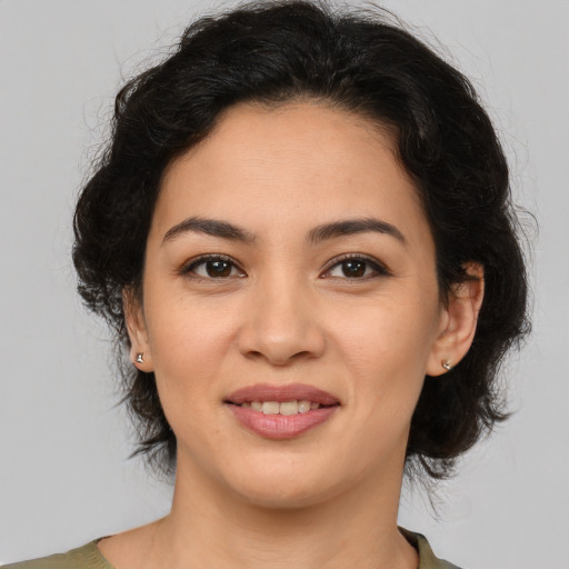 Joyful latino young-adult female with medium  brown hair and brown eyes