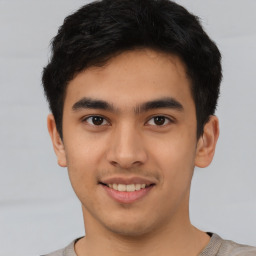 Joyful latino young-adult male with short  brown hair and brown eyes