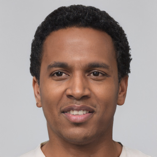 Joyful black young-adult male with short  black hair and brown eyes