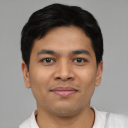 Joyful latino young-adult male with short  black hair and brown eyes