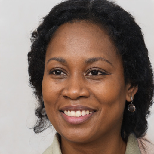Joyful black adult female with long  brown hair and brown eyes
