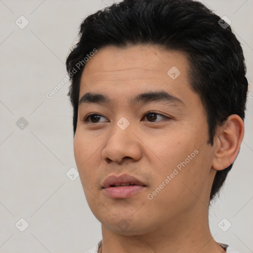 Joyful asian young-adult male with short  black hair and brown eyes