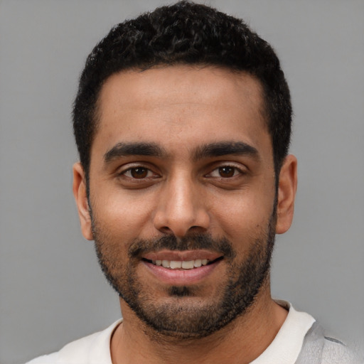 Joyful latino young-adult male with short  black hair and brown eyes