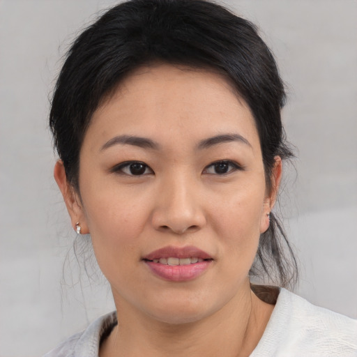 Joyful asian young-adult female with medium  brown hair and brown eyes