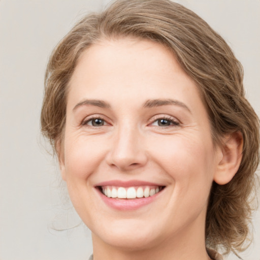 Joyful white young-adult female with medium  brown hair and green eyes