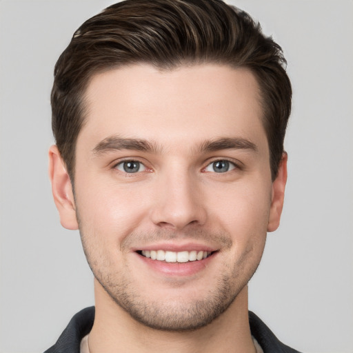 Joyful white young-adult male with short  brown hair and grey eyes