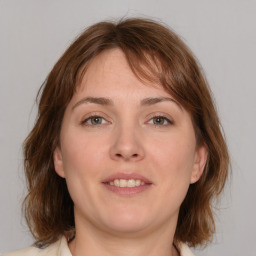 Joyful white young-adult female with medium  brown hair and grey eyes