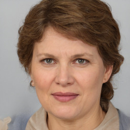 Joyful white adult female with medium  brown hair and blue eyes