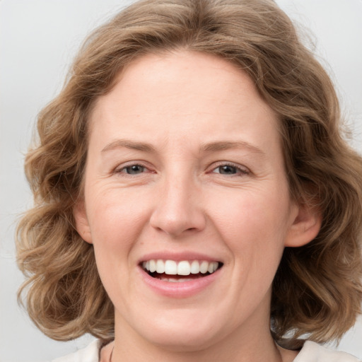 Joyful white young-adult female with medium  brown hair and blue eyes