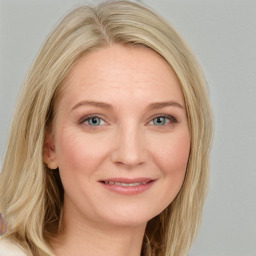 Joyful white young-adult female with long  brown hair and blue eyes