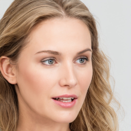 Joyful white young-adult female with long  brown hair and blue eyes